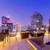 Hilton Dubai The Walk in Dubai rooftop terrace with seating and city skyline at dusk