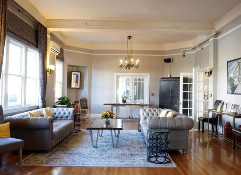 Princess Anne Hotel Asheville lobby with tufted sofas, chandelier, coffee table and hardwood floors