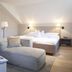Bad Bubendorf Design & Lifestyle Hotel in Bubendorf: modern room with bed, chaise lounge, and open magazine