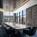 Loews Arlington Hotel conference room with long table, black chairs, floor-to-ceiling windows and city views