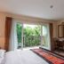Jomtien Beach Residence in Pattaya guest room with balcony doors, garden view, desk and TV