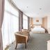 Super Candle Hotel Hanoi guest room with bed, desk, chairs and floor-to-ceiling windows