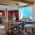 Hosteria Posta de los Colonos dining room in Villa La Angostura with wooden tables and mountain view