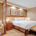 The Signature At Mgm Grand Las Vegas bedroom with king bed, bench, and adjoining bathroom doorway