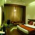Hotel Centre Point in Nagpur guest room with bed, sofa seating and desk under warm lighting