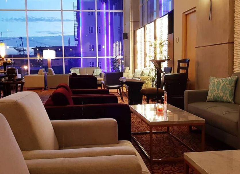 Swiss-Belhotel Borneo Samarinda lobby lounge with city view and purple-lit windows in Samarinda