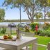 Noosa Outrigger Beach Resort, Noosa Heads: patio table overlooking lawn, river and parked cars