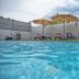 Casa Toñita in Levittown with an outdoor pool and lounge chairs under beige umbrellas