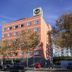 B&B Hotel Figueres in Figueres, exterior of a coral brick hotel building with street trees