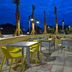 Home2 Suites by Hilton Orlando at FLAMINGO CROSSINGS Town Center patio with tables and yellow chairs at dusk