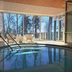 Backby Manor in Espoo: indoor pool with large windows and lounge chairs overlooking trees