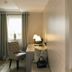 Bad Bubendorf Design & Lifestyle Hotel Bubendorf guest room with desk, chair and window with curtains