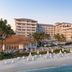 Naples Beach Club, A Four Seasons Resort in Naples with beachfront loungers, palm trees and oceanfront views