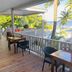 La Isla Resort, Caye Caulker: covered wooden terrace with tables, palm trees, and ocean view