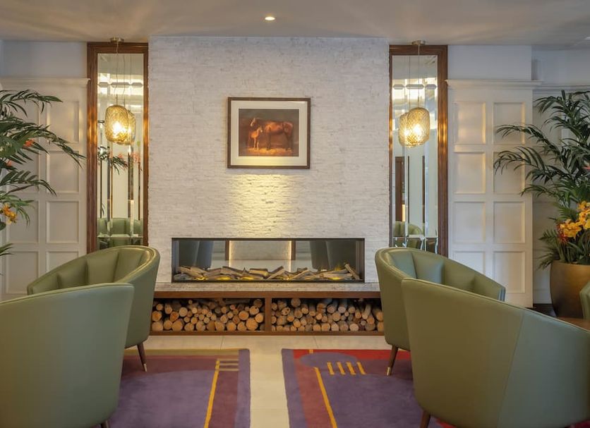 Glenroyal Hotel & Leisure Club in Maynooth lobby with fireplace, olive chairs and potted plants