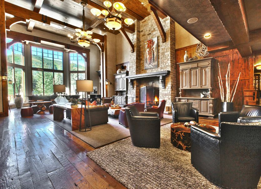 Hotel Park City, Autograph Collection lounge with fireplace, leather chairs, tall windows and rustic wood beams in Park City