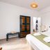 Cyclades Beach Apartments in Platis Gialos bedroom with double bed, bench, wardrobe and wall art