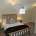 The Kings Head in Meifod bedroom with wooden bed, bedside lamps and small window