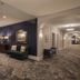 Belleview Inn in Belleair hallway with patterned carpet, green benches, and framed wall art