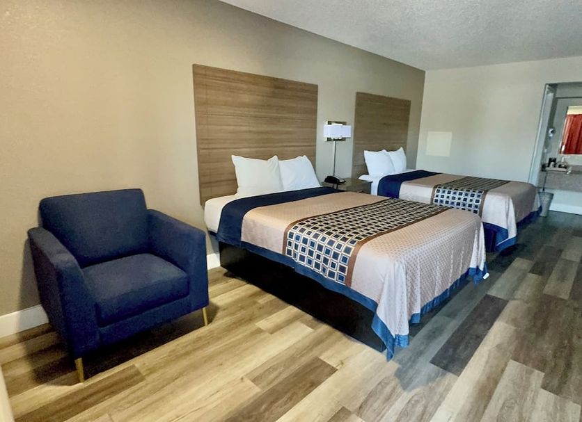 Harrisonville Inn & Suites Harrisonville guest room with two beds, blue chair and wood-look flooring