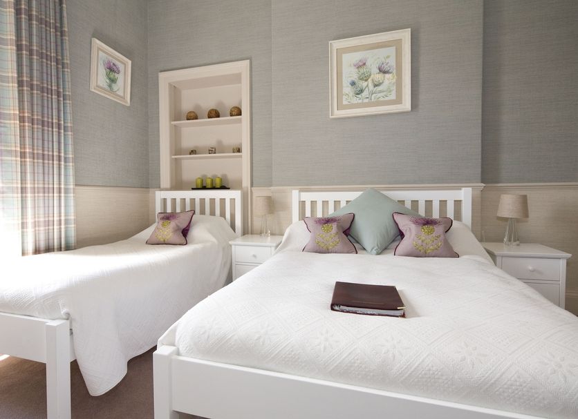 Sherwood Guest House in Edinburgh twin bedroom with white beds, bedside tables, and plaid curtains