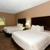 Cobblestone Inn & Suites - Denison guest room with two beds and window view