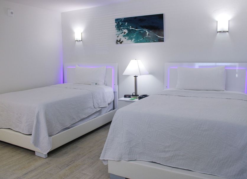 The Bay Inn at the Lani Kai in Fort Myers Beach guest room with two white beds and bedside lamp