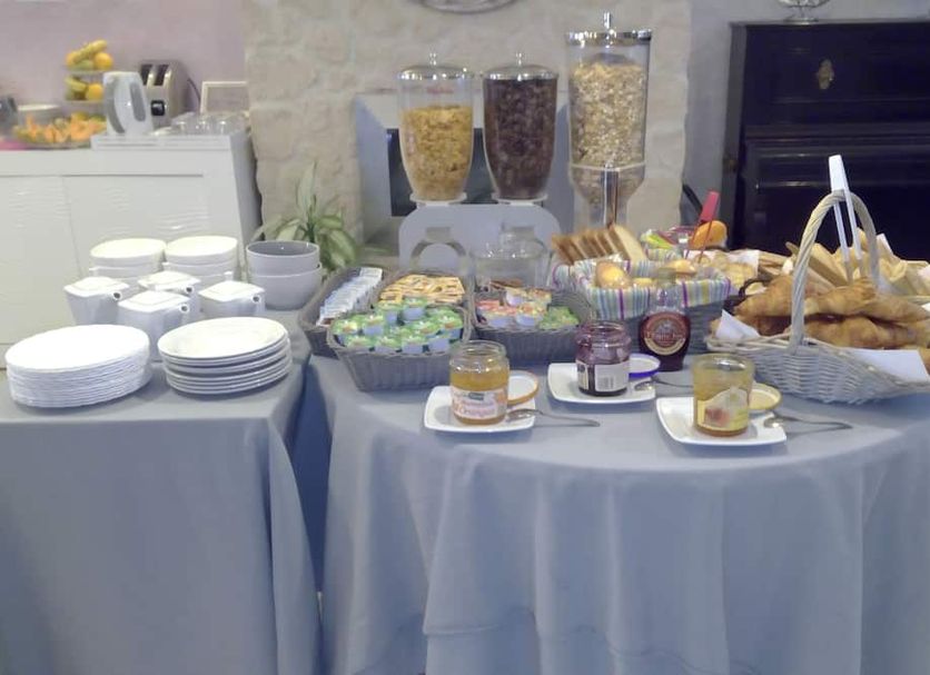 Hotel De La Bastide breakfast buffet with pastries, cereal dispensers and stacked plates in Carcassonne