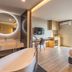 56 Hotel Bangkok room with freestanding tub, sink vanity, desk, bed and city view