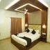 Hotel Arunachala in Tiruvannāmalai bedroom with king bed, wood accent wall and ceiling fan