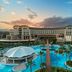 Kaya Palazzo Golf Resort in Belek with large outdoor pool, palm trees and sunset view