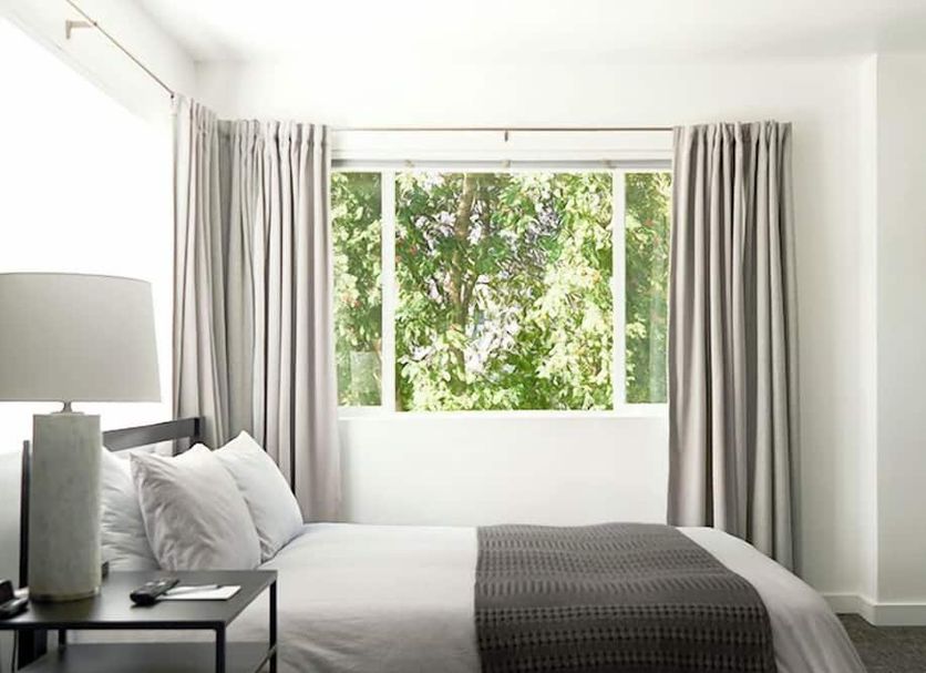 Snob Hollow Inn Anchorage guest room with king bed and large window overlooking trees