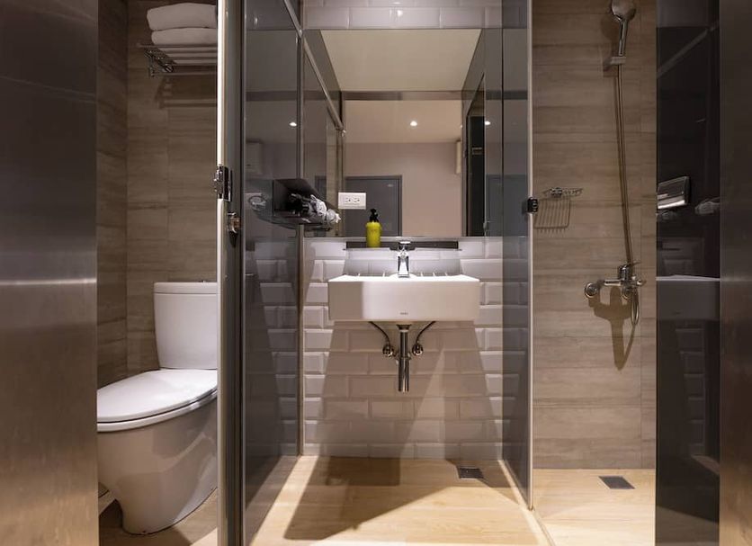 Meander Taipei bathroom with toilet, glass shower, and wall-mounted sink in Taipei City