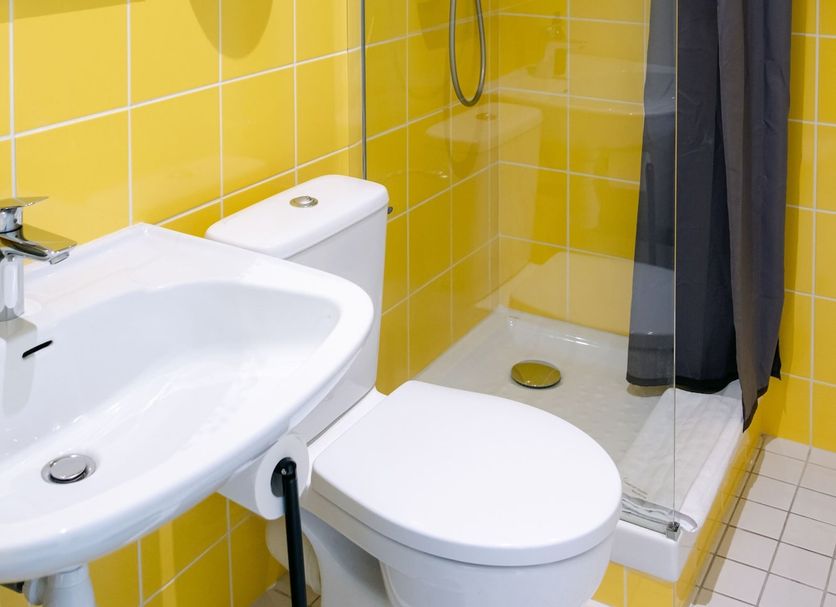 Le Lieu Dit in Nantes bathroom with yellow tiled shower, toilet, and sink