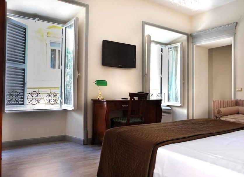 Sleep In Rome Ludovisi guest room with bed, desk, wall-mounted TV and open windows in Rome