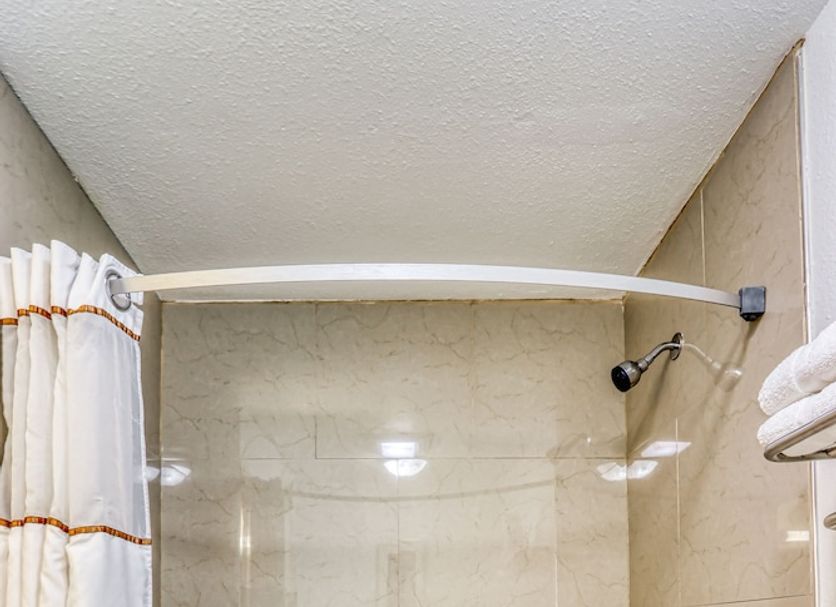 Americas Hotel El Paso Medical Center Airport bathroom with bathtub, shower, and grab bar in El Paso