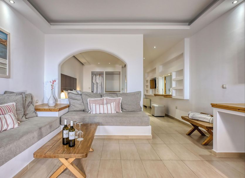 Splendour Hotel and Suites in Firostefani: airy suite with sofa seating, wood table and arched opening