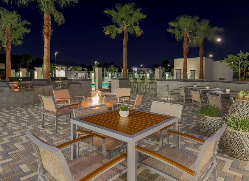 Element Ontario Rancho Cucamonga patio with fire pit seating, palm trees and planters in Ontario
