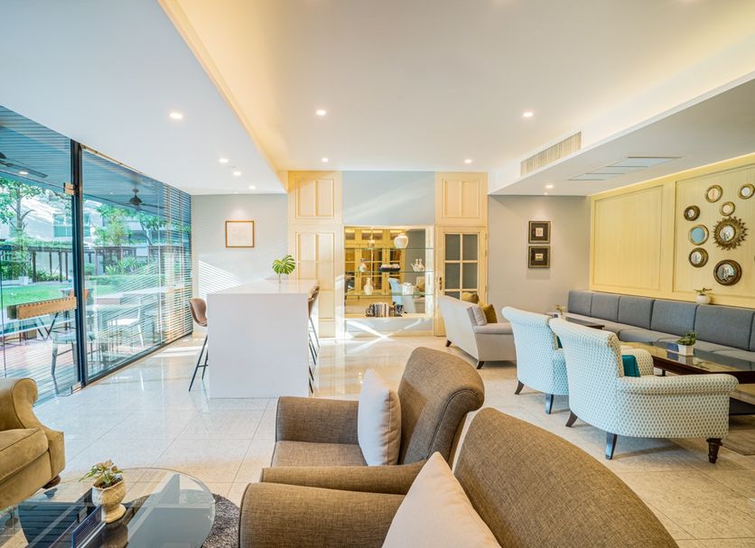 Shama Petchburi 47 Bangkok lobby lounge with glass doors opening to a green patio in Bangkok