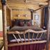 Gold Mountain Manor in Big Bear log cabin bedroom with rustic wooden canopy bed and window blinds