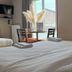 Hôtel La Métairie in Cordes-sur-Ciel guest room with twin beds, table by window, and pampas grass decor