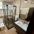 Nif Ankara Hotel bathroom with glass shower, toilet, sink and wall-mounted towel rack in Ankara