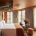 Le Grand Mazarin Paris guest room with canopy bed, French doors and balcony view