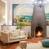 Hotel Sant Roc lobby with central fireplace, two sofas and seaside mural in Calella de Palafrugell