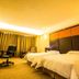 Changchun Huatian Hotel in Changchun guest room with two beds, desk, chairs and curtained window