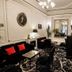 Hotel Peyris Opera in Paris lounge with black sofas, ornate rug, chandeliers and classic wall decor