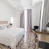 Carmelita Valletta guest room with chandelier, patterned floor, desk, and large bed in Valletta