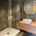 Hôtel confidentiel Le Grecale bathroom with walk-in shower, vessel sink, and round mirror in Pianottoli-Caldarello