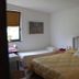 Flegrea House - Casa Rosa guest room in Pozzuoli with twin and double beds, wall clock, and window