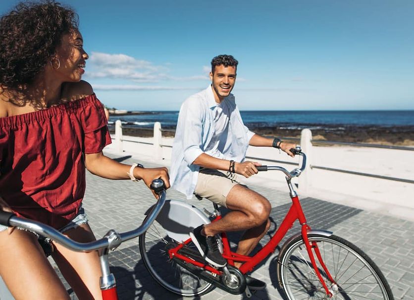 Guests ride bicycles along the beach promenade at Hotel Riu Oliva Beach Resort in Corralejo.